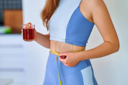 Téléchargez les photos : Fitness sportive femme en bonne santé boire une tisane pour la perte de poids et le corps mince - en image libre de droit