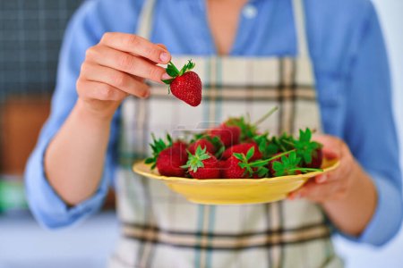 Téléchargez les photos : Assiette femelle avec fraises biologiques fraîches mûres à la cuisine maison - en image libre de droit