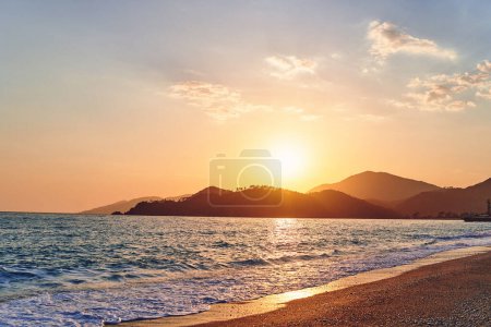 Téléchargez les photos : Paysage de beau ciel idyllique coucher de soleil, mer, plage de sable et montagnes - en image libre de droit