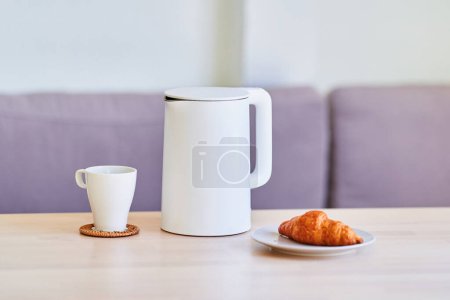 Foto de Moderno hervidor eléctrico blanco para preparar té en la mesa en casa - Imagen libre de derechos