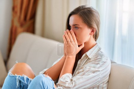 Téléchargez les photos : Anxiété déprimée solitaire pleurant femme mélancolique assise dans les pensées seule à la maison - en image libre de droit