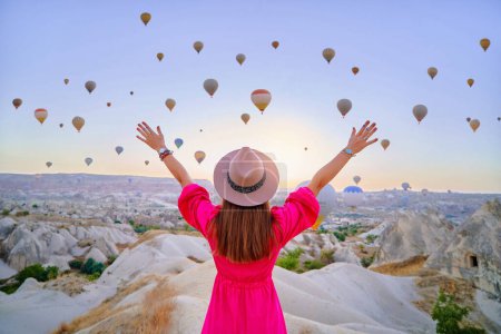 Téléchargez les photos : Retour de fille libre insouciante heureux inspiré voyageur à bras ouverts profiter de ballons à air volant en Anatolie, Kapadokya. Belle destination à Nevsehir, Goreme - en image libre de droit