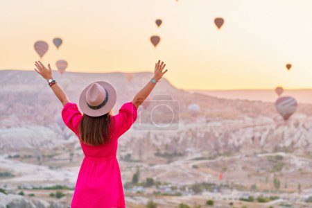 Téléchargez les photos : Voyageuse heureuse gratuite à bras ouverts profitant de ballons volants en Anatolie, Kapadokya. Belle destination à Nevsehir, Goreme - en image libre de droit