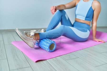 Photo for Woman using roller for self muscle massage - Royalty Free Image