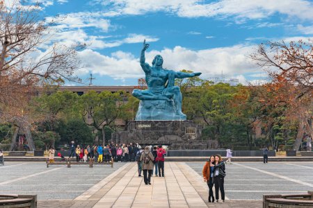 Téléchargez les photos : Nagasaki, kyushu - dec 11 2019 : Un groupe de touristes chinois faisant des selfies en visitant la statue de la paix créée par le sculpteur japonais Seibo Kitamura inspiré par l'athlète Hiroichi Yoshida. - en image libre de droit