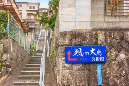 Téléchargez les photos : Kyushu, nagasaki - 14 décembre 2021 : Panneau d'information guidant vers le Musée Kazenodaichi par une pente raide avec des escaliers étroits montant entre les maisons japonaises sur les coteaux du parc Kazagashira. - en image libre de droit