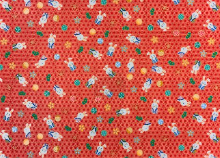 Téléchargez les photos : Photographie d'un tissu furoshiki japonais traditionnel imprimé de mignons lapins en hakama symbole de fortune, avançant et astucieux sur fond de feuilles de chanvre appelées asanoha. - en image libre de droit