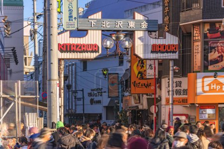 Téléchargez les photos : Tokyo, setagaya - january 28 2023: Main gate of the Azuma Dori shopping street meaning East Street in the district of Shimokitazawa with crowds of people strolling during the tengu parade festival. - en image libre de droit