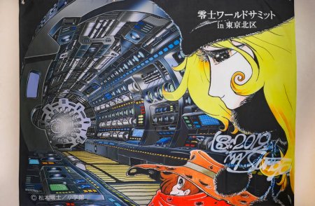 Téléchargez les photos : Tokyo, Japon - nov 02 2019 : Affiche en tissu signée par le créateur de mangas japonais Leiji Matsumoto pour le Sommet mondial de Leiji illustrée par Maetel et Tetsuro dans le train spatial de la série Galaxy Express 999. - en image libre de droit