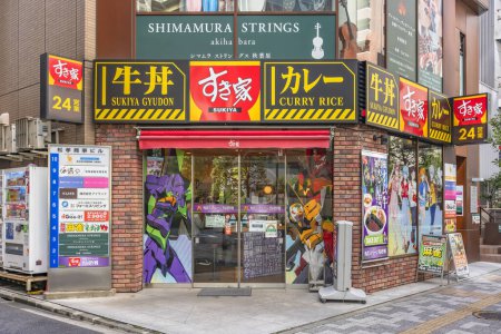 Photo for Tokyo, akihabara - mar 29 2021: Fast food Sukiya restaurant which windows are decorated by wrapping stickers featuring characters and robots of famed Japanese manga and anime Neon Genesis Evangelion. - Royalty Free Image