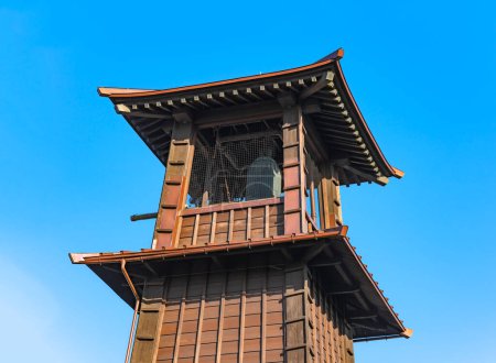 Photo for Tokyo, japan - dec 31 2022: Low angle view of the top of the landmark building of the three-story Time Bell Tower builded in Kurazukuri style in Kawagoe which is rung mechanically four times a day. - Royalty Free Image