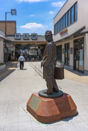Téléchargez les photos : Tokyo, Japon - 18 juillet 2023 : Statue en bronze de la célèbre star japonaise Tora-san dans la série de films Otoko wa tsurai yo debout avec sa valise devant la gare de Shibamata. - en image libre de droit
