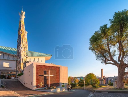Foto de Nagasaki, Kyushu - 11 dic 2022: Puesta de sol sobre la iglesia de San Filippo Nishizaka cuyas torres fueron creadas en 1962 por el arquitecto japonés Kenji Imai, inspirado en la Sagrada Familia de Antonio o Antoni Gaudí - Imagen libre de derechos