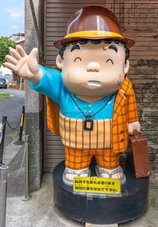 Téléchargez les photos : Tokyo, Japon - 18 juillet 2023 : Grande statue en plastique représentant la caricature manga de la célèbre star de cinéma japonaise Tora-san dans la série de films Otoko wa tsurai yo debout à Shibamata. - en image libre de droit