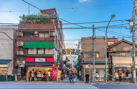 Foto de Tokyo, Japón - sep 17 2023: Gente paseando por el distrito de Komagome bajo el arco metálico adornado con la encantadora mascota Shiichan que marca la entrada a la calle comercial Shimofuri. - Imagen libre de derechos