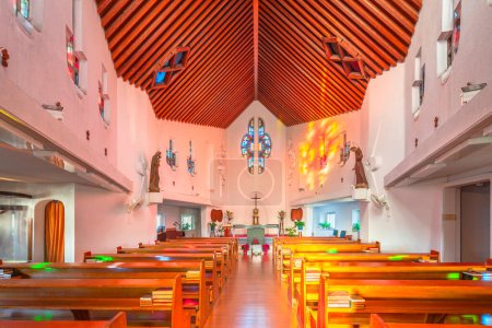 Foto de Nagasaki, kyushu - dic 12 2022: Interior de la Iglesia de San Filippo Nishizaka creada en 1962 por el arquitecto japonés Kenji Imai con un techo de madera y coloridas vidrieras que dejan entrar la luz del sol. - Imagen libre de derechos