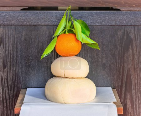 Photo for Traditional Japanese New Year decoration Kagami Mochi with two stacked rice cakes topped with a bitter orange Daidai with leaves attached which is a namesake of the phrase "generation to generation". - Royalty Free Image