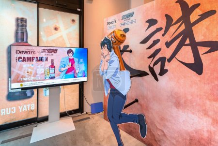 Photo for Tokyo, japan - aug 9 2023: Collaboration campaign event between the Japanese anime City Hunter and the Dewar's whisky on an advertising screen aside a life-size standee of Saeba Ryo aka Nicky Larson. - Royalty Free Image