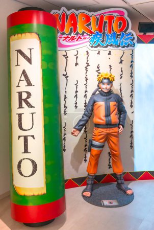 Téléchargez les photos : Ikebukuro, Japon - 16 jan 2024 : Figurine grandeur nature mettant en vedette le héros manga de Naruto Shippuden à côté d'un rouleau géant à l'entrée de l'exposition gratuite de Naruto à la station Anime Tokyo. - en image libre de droit