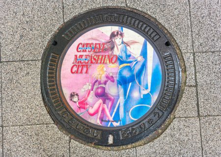 Téléchargez les photos : Tokyo, Japon - 25 avril 2024 : Trou d'homme humide illustré avec les héroïnes du manga japonais et de la série télévisée Cat's Eye illustrée par Tsukasa Hojo pour la ville de Musashino à Kichijoji. - en image libre de droit