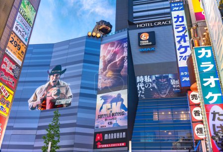 Téléchargez les photos : Tokyo, Japon - 28 avril 2024 : Façade des cinémas Shinjuku Toho dominés par un chef de Godzilla et présentant des affiches et des autocollants du film japonais Netflix "City Hunter" et du film Godzilla - Kong - en image libre de droit