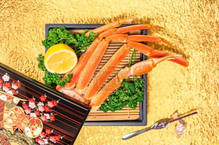 Un festin de fruits de mer luxueux dispose de pattes de crabe fraîches sur un tapis de bambou accompagné de citron et de persil sur un fond doré avec une boîte japonaise laquée traditionnelle pour une image gastronomique.