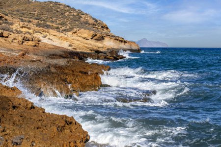Rugged, rocky coast with surf in Cabo Cope and Puntas de Calnegre Regional Park, Murcia, Spain, in daylight