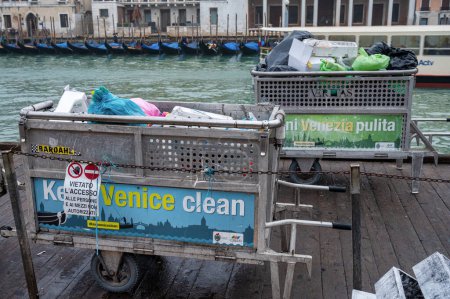 Téléchargez les photos : Venise, Italie- 23 févr.2023 : Poubelles remplies de déchets près du Grand Canal de Venise prêtes à être ramassées. - en image libre de droit