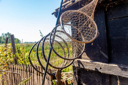 Photo for Fishing tools hang on the roof of a log cabin in Zasavica nature reserve, Serbia - Royalty Free Image