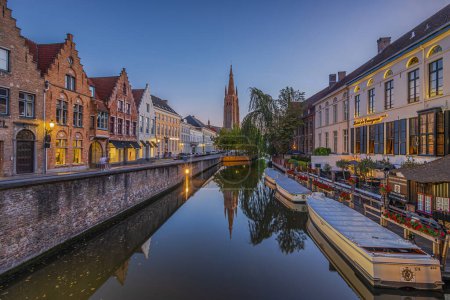 Beleuchteter Kanal in der Altstadt von Brügge. Abendstimmung in der belgischen Hansestadt mit historischen Gebäuden und alten Kaufmannshäusern. Spiegelungen an der Wasseroberfläche