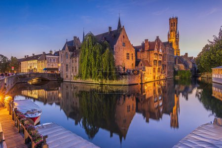 Photo for Reflection of the historic buildings from the canal of the Rosary Quay in the Hanseatic city of Bruges. Belfry of the old town and historic guild houses and merchant houses in an evening atmosphere. - Royalty Free Image
