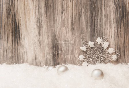 Christmas Wooden background with Christmas tree decorations and artificial snow