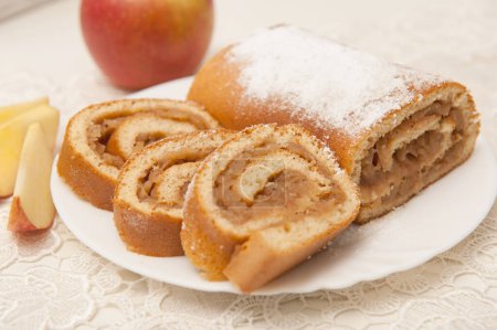 Téléchargez les photos : Rouleau de pomme biscuit sur une assiette sur une serviette en dentelle - en image libre de droit