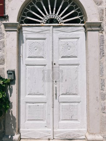 Photo for White wooden door with an arched top in the stone wall of an ancient building. High quality photo - Royalty Free Image