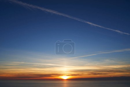 Téléchargez les photos : Coucher de soleil orange sur le ciel bleu sur la mer. Photo de haute qualité - en image libre de droit