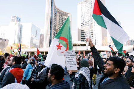 Foto de Multitud de manifestantes en un entorno urbano, ondeando varias banderas, incluida la palestina y una con una estrella. Edificios de la ciudad al fondo. Foto de alta calidad - Imagen libre de derechos