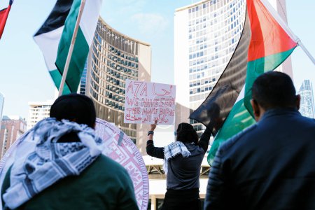 Foto de Manifestantes ondeando banderas palestinas en un entorno urbano. Uno sostiene un letrero que dice Hemos visto esta película antes. Los edificios de la ciudad forman el telón de fondo. .. Foto de alta calidad - Imagen libre de derechos