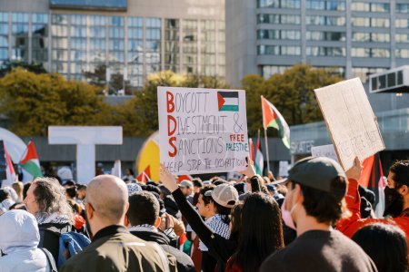 Téléchargez les photos : Toronto, Canada - 28 octobre 2023 : Des manifestants défilent dans la ville, arborant des pancartes prônant le boycott, le désinvestissement et les sanctions contre l'occupation et soutenant la Palestine. Photo de haute qualité - en image libre de droit