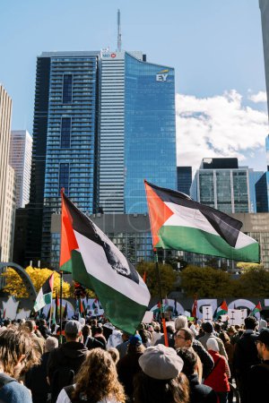 Foto de Toronto, Canadá - 28 de octubre de 2023: La multitud se reúne en un entorno urbano, con destacadas banderas palestinas ondeando sobre un telón de fondo de rascacielos. Foto de alta calidad - Imagen libre de derechos