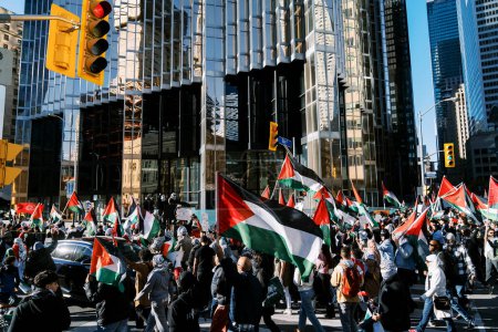 Téléchargez les photos : Marche anti-guerre à Toronto par des Palestiniens contre l'agression israélienne à Gaza. Cite une manifestation pacifique contre la guerre israélo-hamas. Les manifestants agitent des drapeaux contre. Génocide palestinien. - en image libre de droit