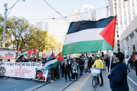 Téléchargez les photos : Toronto, Canada - 28 octobre 2023 : Les places de Torontos regorgent de drapeaux et de chants palestiniens, exigeant la fin des hostilités israéliennes à Gaza. Photo de haute qualité - en image libre de droit