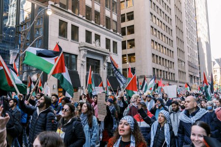 Téléchargez les photos : Marche anti-guerre à Toronto par des Palestiniens contre l'agression israélienne à Gaza. Cite une manifestation pacifique contre la guerre israélo-hamas. Les manifestants agitent des drapeaux contre. Génocide palestinien. - en image libre de droit