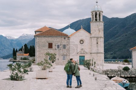 Photo for Man and woman kiss on the island of Gospa od Skrpjela, holding hands. Montenegro. High quality photo - Royalty Free Image