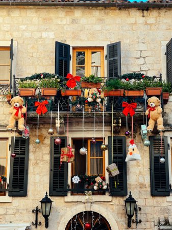 Photo for Christmas decorations hang from the balcony of an old stone house. High quality photo - Royalty Free Image