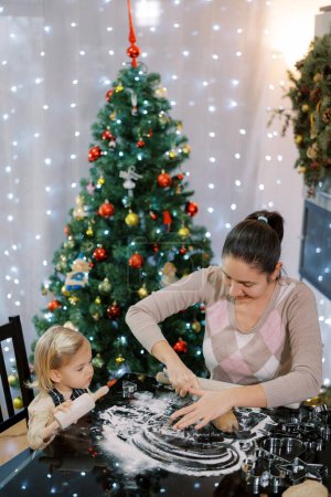 Foto de Niña viendo a su madre cortando pasta en la mesa. Foto de alta calidad - Imagen libre de derechos
