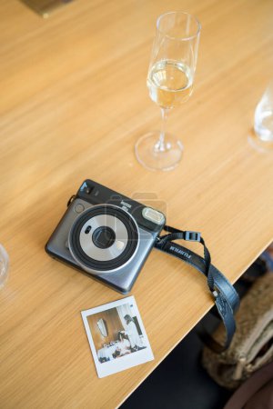 Foto de Fujifilm instax cuadrado sq6 cámara instantánea se encuentra en la mesa junto a la fotografía. Foto de alta calidad - Imagen libre de derechos