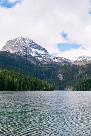 Photo for Black lake in a valley with a coniferous forest on the shore at the foot of Mount Bobotov Kuk. Durmitor, Montenegro. High quality photo - Royalty Free Image