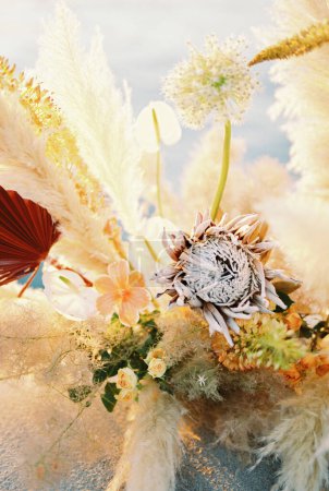 Colorful wedding bouquet with dried flowers stands on the pier. Close-up. High quality photo