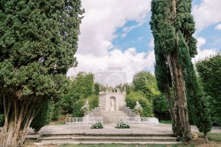 Filas de sillas con ramos de flores están en la plataforma cerca de la estatua en Pozega Park. Villa Rizzardi. De Italia. Foto de alta calidad