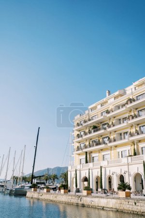 Photo for Luxurious Regent Hotel on the seafront next to moored sailing yachts. Porto, Montenegro. High quality photo - Royalty Free Image